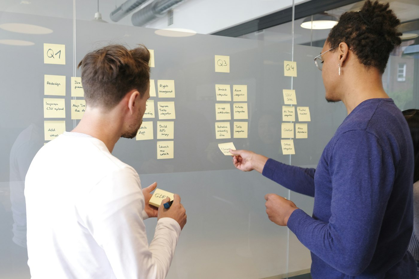 Two people planning a weekly SEO routine with sticky notes